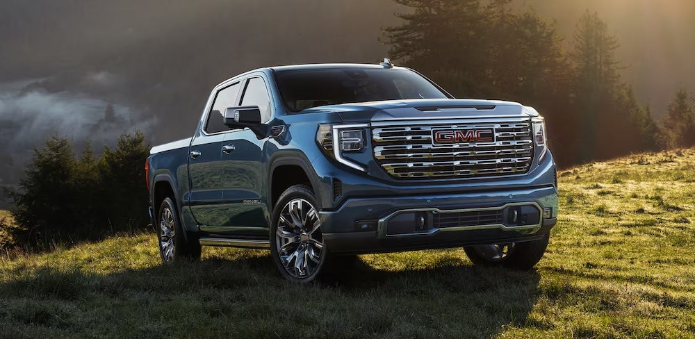 A blue 2026 GMC Sierra 1500 truck on a grassy hill