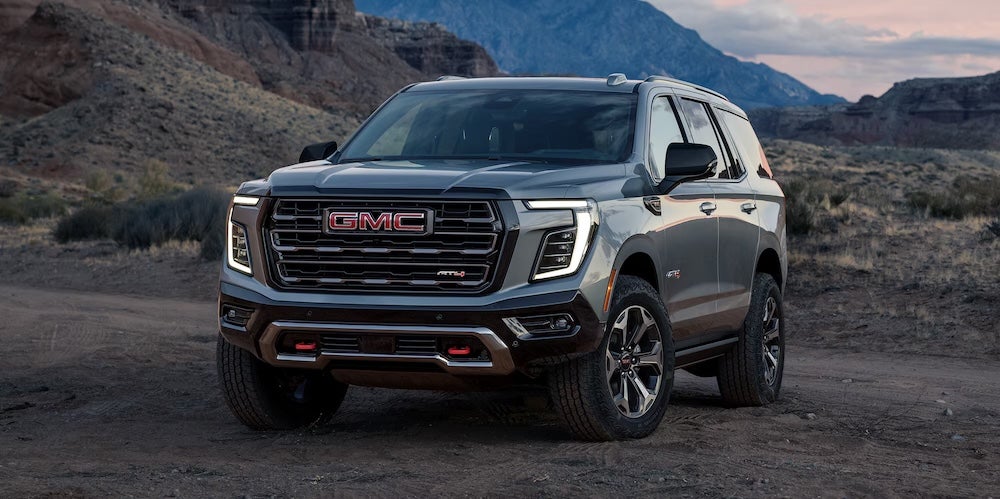 A gray 2026 GMC Yukon SUV parked at the base of a mountain