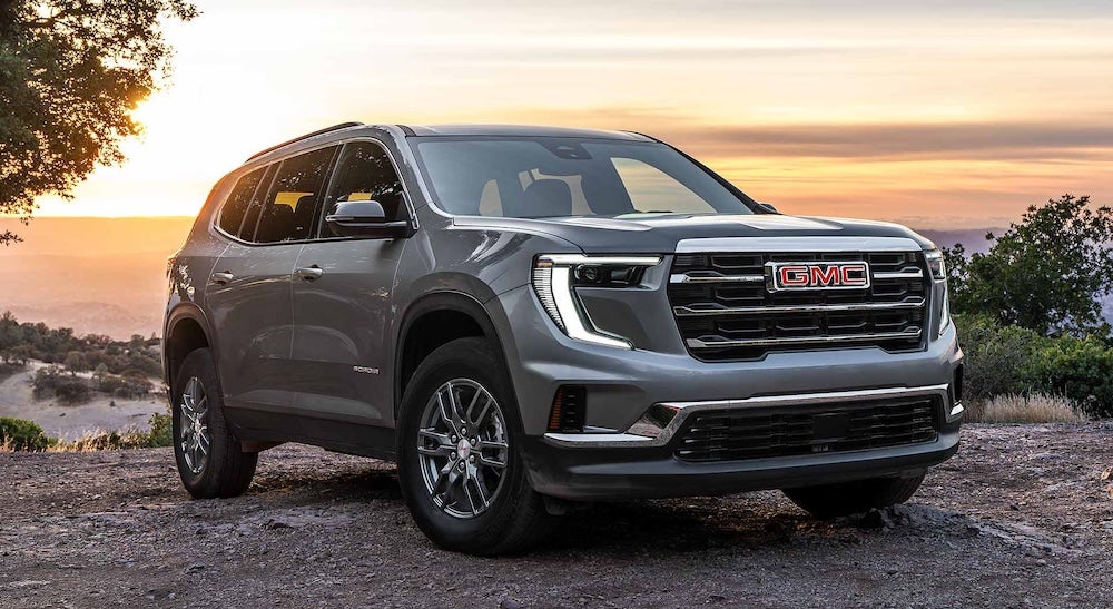 A gray GMC Acadia SUV at sunset