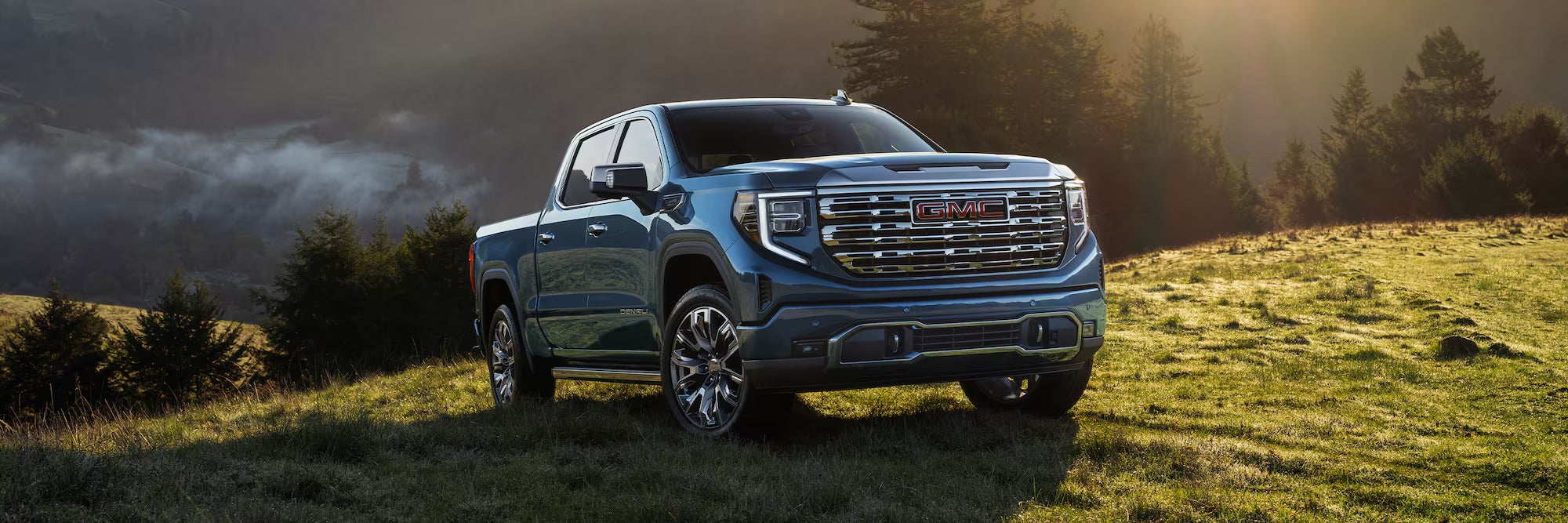 A gray 2026 GMC Sierra 1500 pickup truck in a grassy field