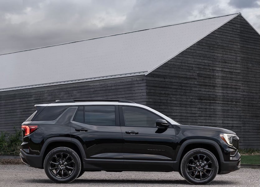 A black 2026 Terrain SUV parked outside a wood barn