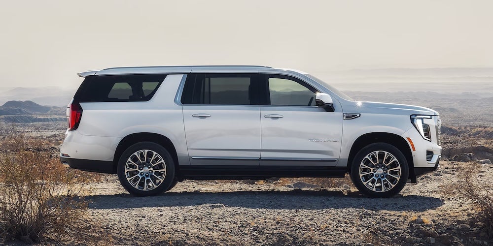 A side view of a 2027 GMC Yukon SUV parked in the desert